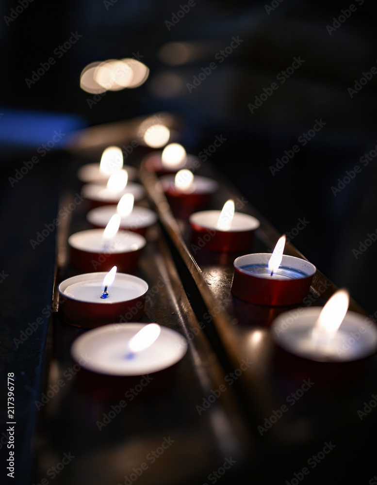 Candele e lumini con fiammelle su appoggi di rame Stock Photo
