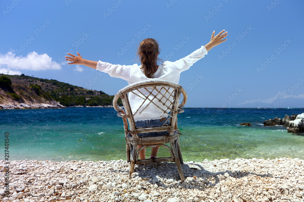Happy young girl on a background of a sea landscape with open hands.