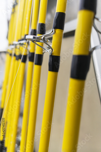 Close up of yellow lined fishing poles in a boat.