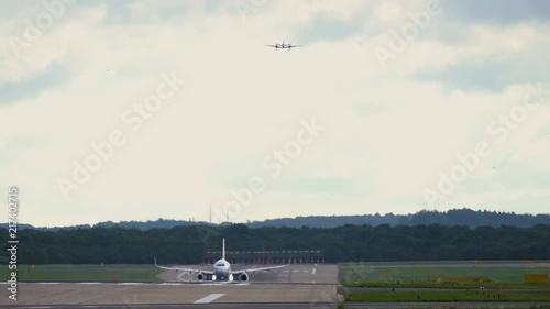 Jet plane take off. Bussines plane approaching to the same runway photo