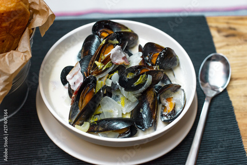 Mussels with onions and bacon in cream sauce in deep plate