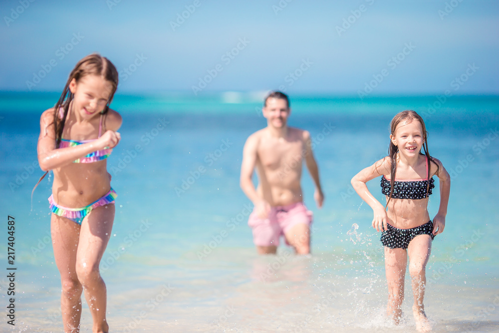 Father and little kids enjoying beach summer tropical vacation