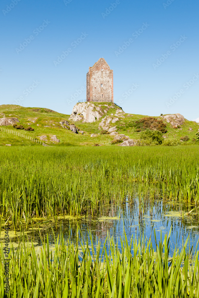 Smailholm Tower.  The view across a mill pond towards Smailholm Tower in the Scottish Borders.  The tower was built in the 1400's as protection from border raiders and the elements.