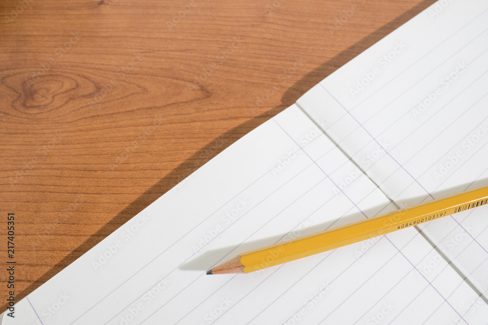 Copybook and a pencil on a wood table Copybook and a pencil on a wood table