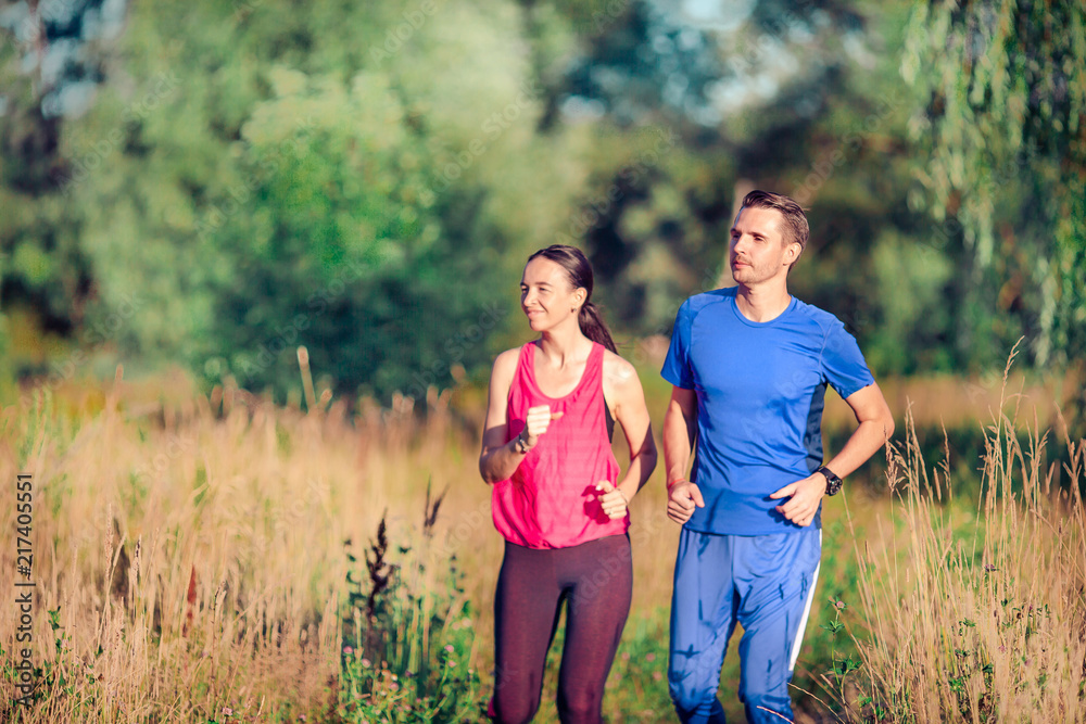 Active sportive couple running in park. Health and fitness.