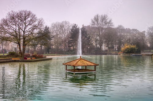  the public Parc de Merl in Luxembourg city, Luxembourg, featuring a lake with ducks and a water fountain in the background.