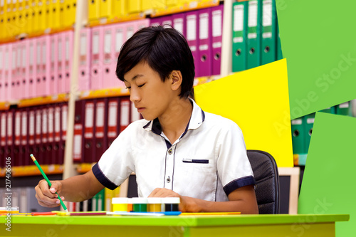 Portrait classman schoolboy study sitting books asian boy lesson school board briefcase backpack pencil globe yellow green photo