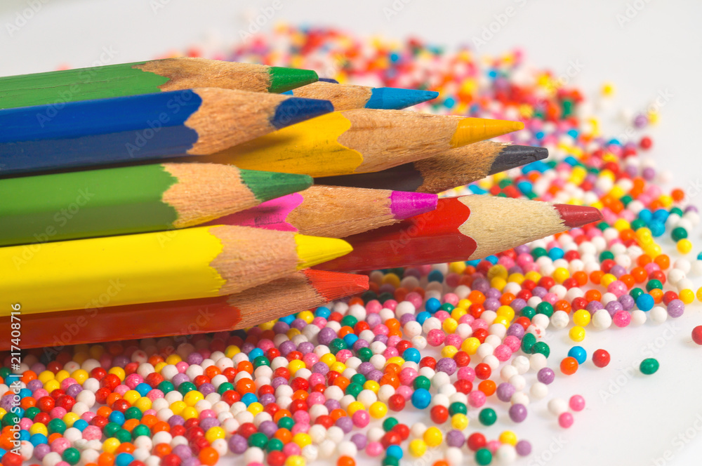 Color pencils on the background of texture multi-colored balls close-up. Set for children's creativity and development