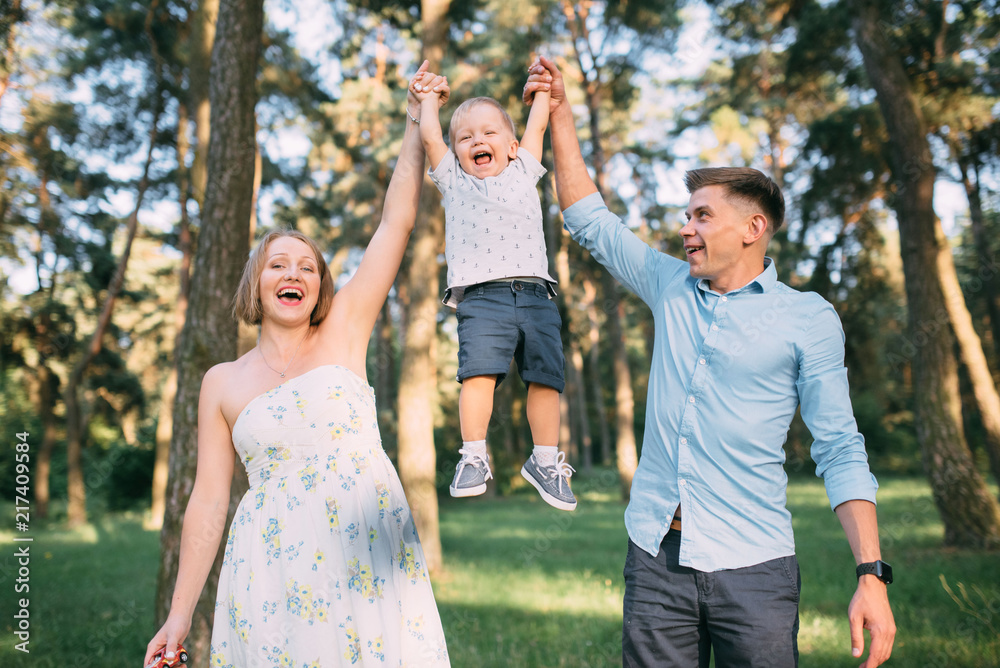 A cute family - mom, dad and son spend fun time in nature A cute family - mom, dad and son spend fun time in nature