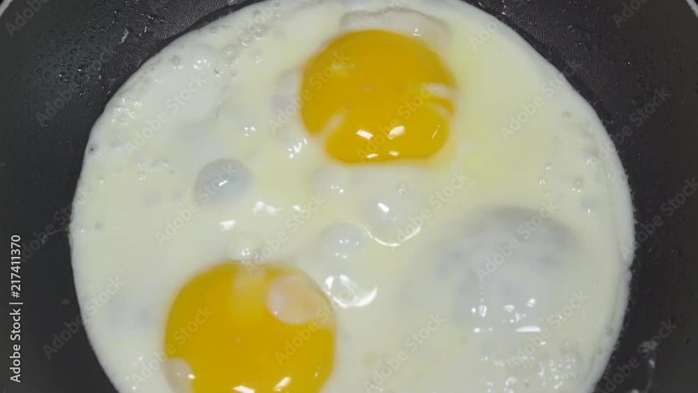 Cooking sunny side up eggs for breakfast. Close up slider shot. Cooking sunny side up eggs for breakfast. Close up slider shot.