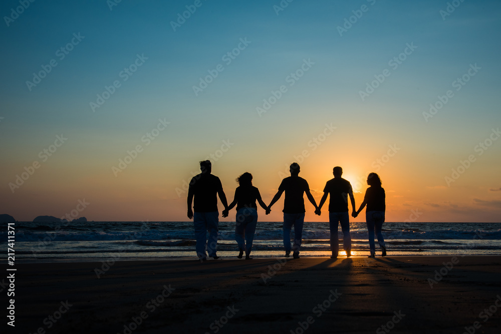 Familia tomada de la mano feliz en la playa