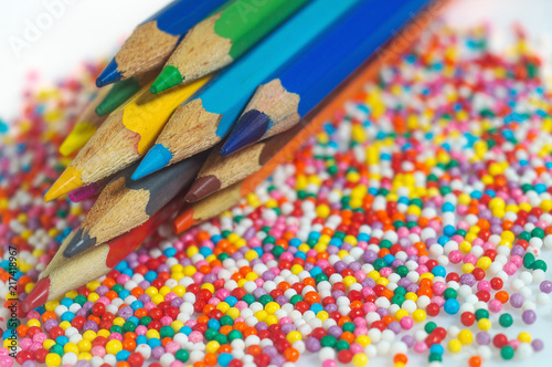 Color pencils on the background of texture multi-colored balls close-up. Set for children's creativity and development