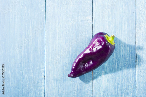 purple chili pepper on blue wooden table background
