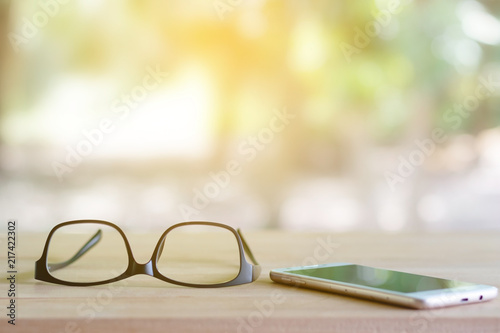 Glasses on the phone are placed on the table.Eye care from technology.