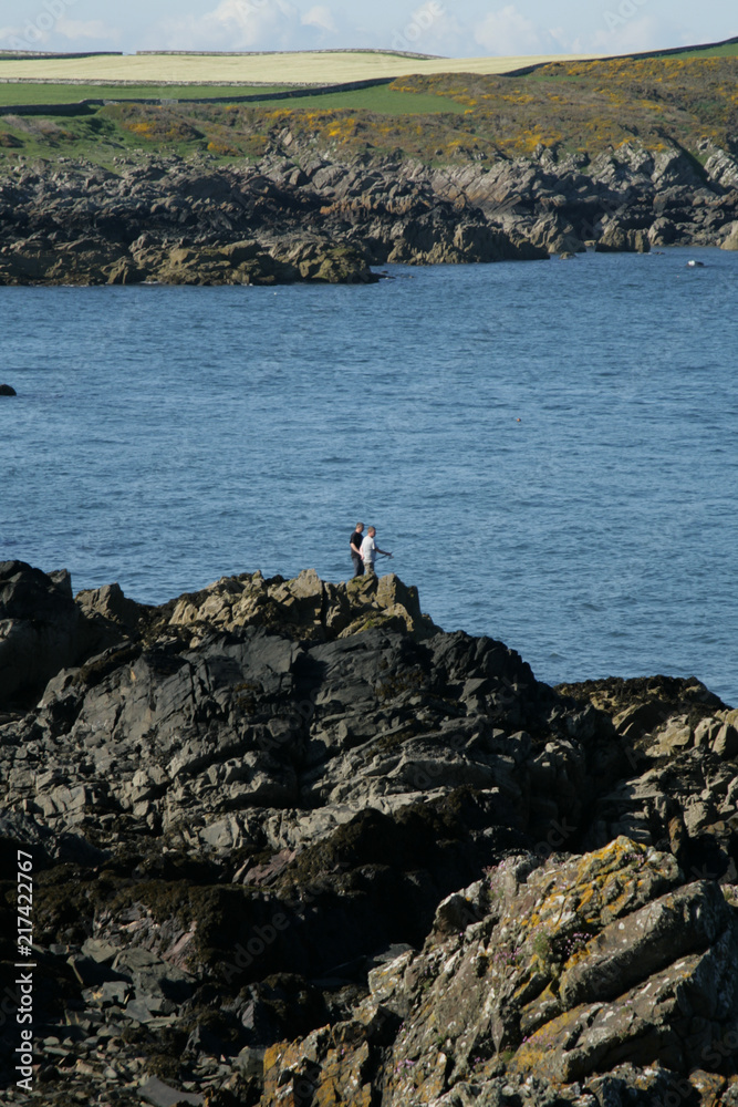 Two caucasian men fishing on rocks, Dumfries and Galloway