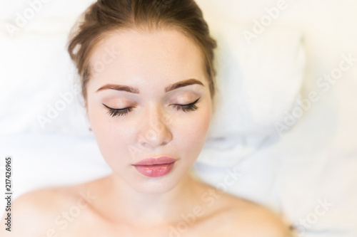Young beautiful girl in spa salon. The girl lies on the couch for a massage after a rejuvenation procedure