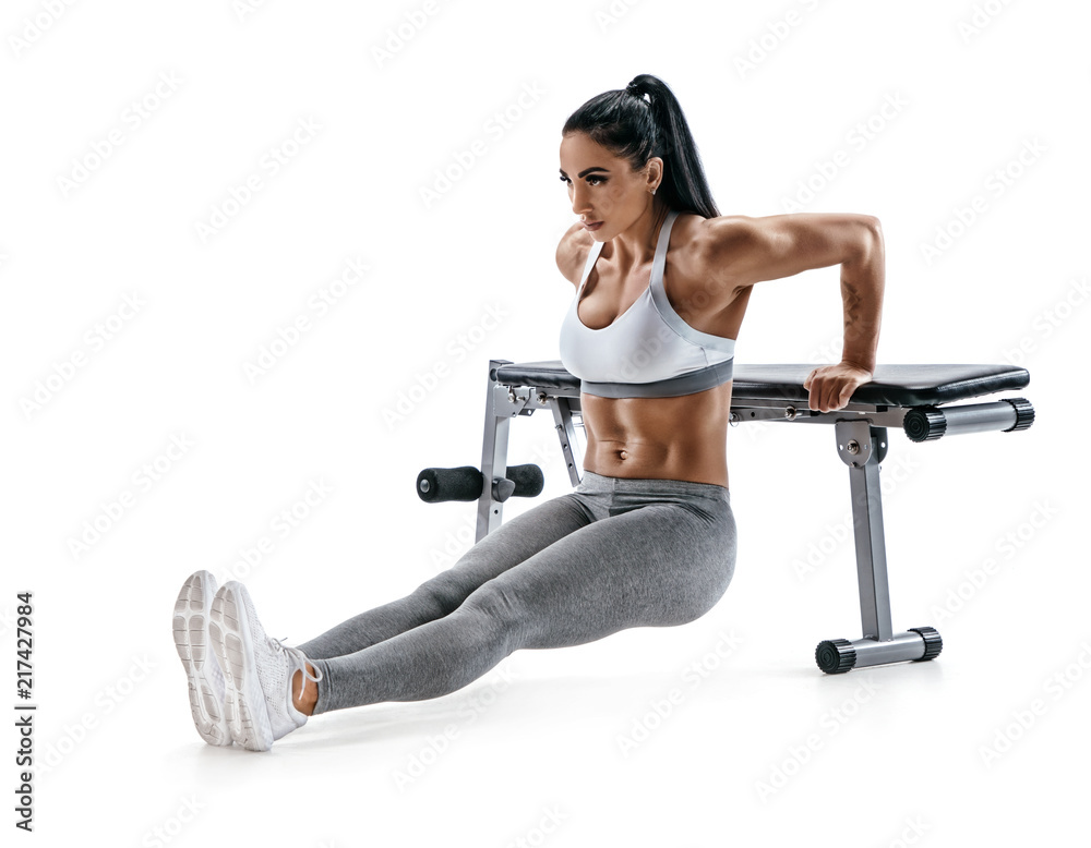 Strong woman working out arms muscles doing triceps dips using bench. Photo of latin woman with perfect body on white background. Strength and motivation Stock Adobe Stock