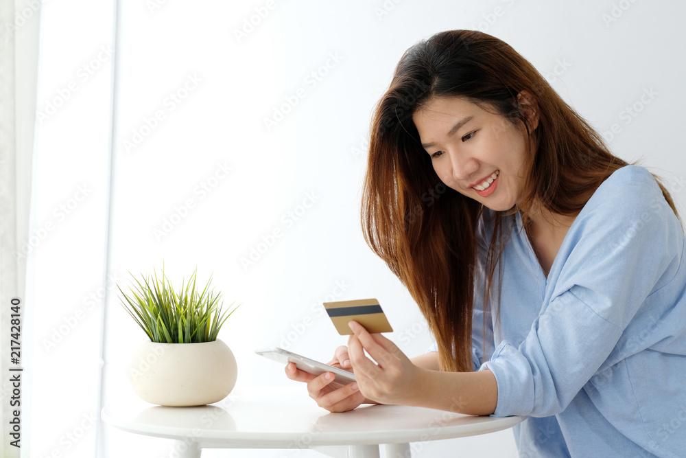 Young asian woman holding credit card and using smart phone for shopping online, business and technology concept, online payment, digital money Young asian woman holding credit card and using smart phone for shopping online, business and technology concept, online payment, digital money