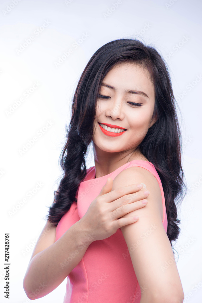 Pretty asian young woman applying cream on her body Pretty asian young woman applying cream on her body