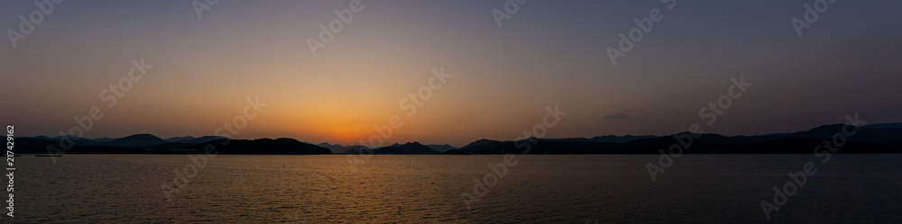 Panorama of beautiful sunset scene at the mountain and sea shore.