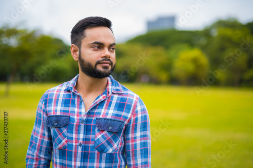 Portrait Of Young Handsome Indian Man In Park Thinking