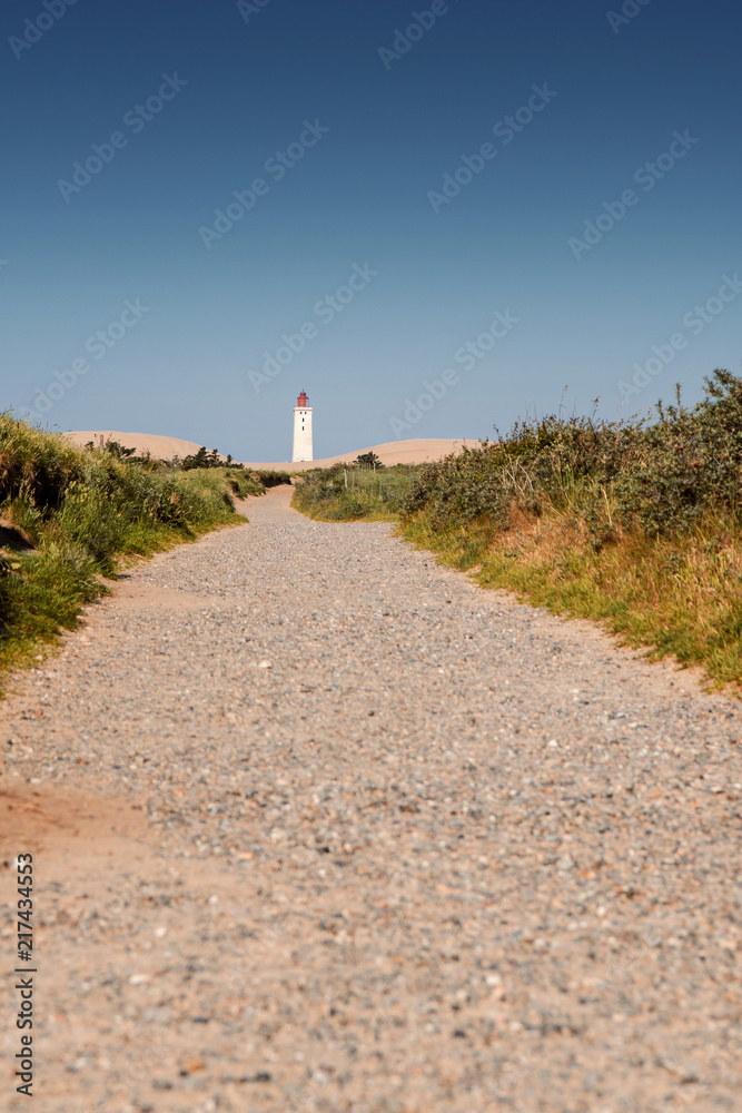 Famous Lighthouse landmark and travel spot with epic sand dunes and grass landscape in beautiful summer sunset. Rubjerg Knude Lighthouse, Lønstrup in North Jutland in Denmark, Skagerrak, North Sea