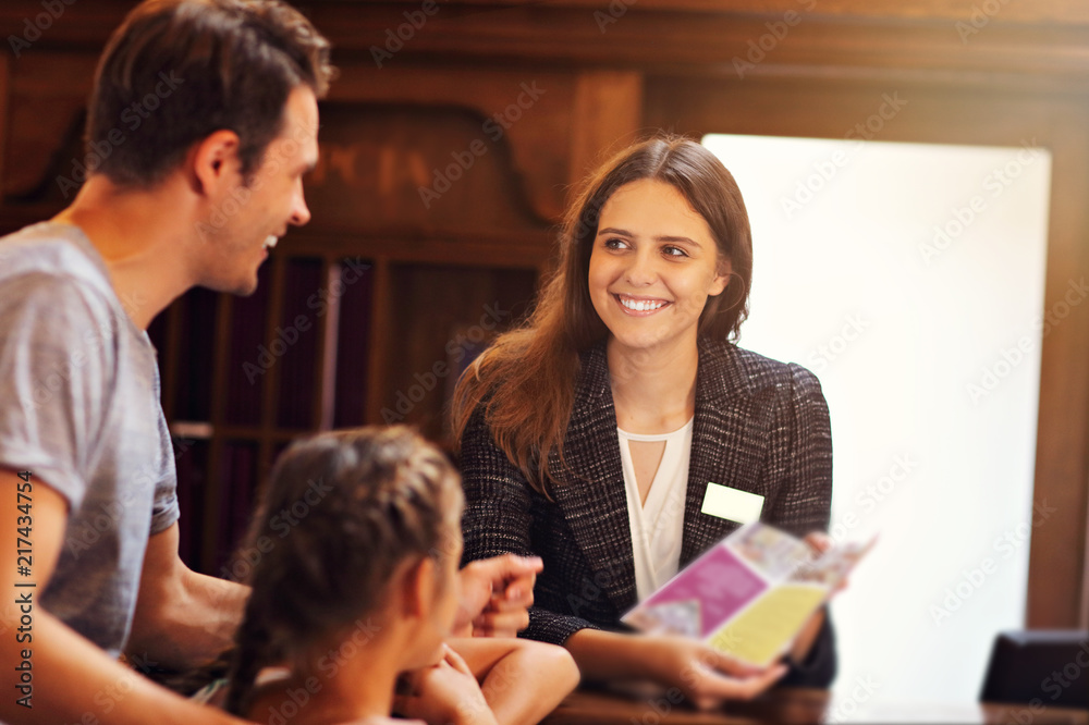 Happy family checking in hotel at reception desk Happy family checking in hotel at reception desk