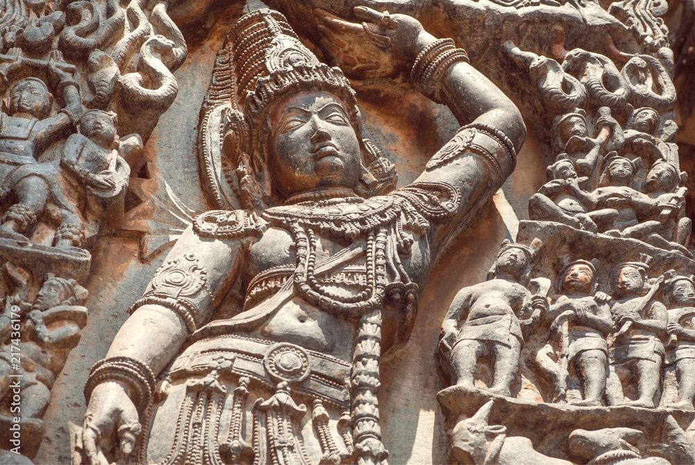 Lord Krishna with a hand raised over human, on relief of the 12th century South Indian temple. Halebidu heritage, India