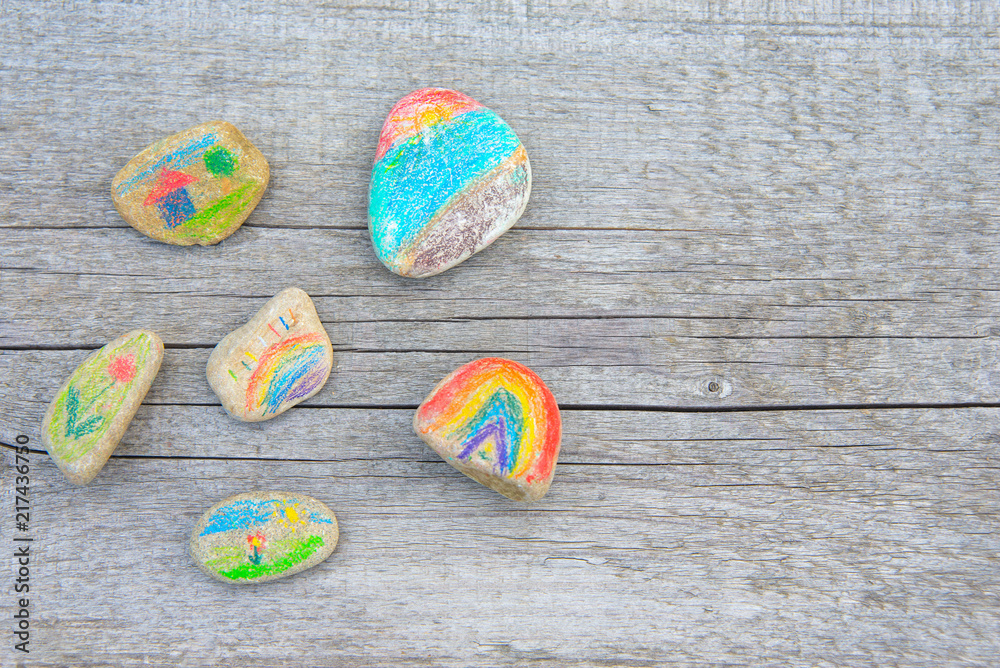 Background from a naturally old wooden board on which lie the pebbles painted with pencils. Background from a naturally old wooden board on which lie the pebbles painted with pencils.