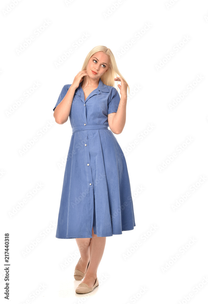 full length portrait of blonde girl wearing blue dress. standing pose. isolated on white  studio background.