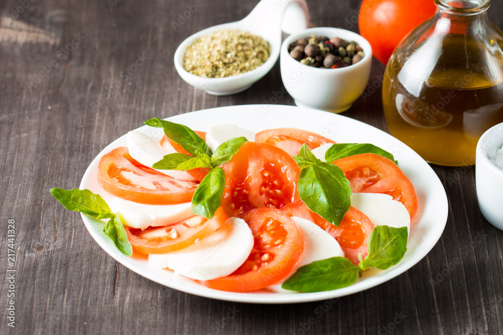 Close-up photo of caprese salad with ripe tomatoes, basil, buffalo mozzarella cheese. Italian and Mediterranean food concept. Fresh and healthy organic meal. Starter and antipasti. Close-up photo of caprese salad with ripe tomatoes, basil, buffalo mozzarella cheese. Italian and Mediterranean food concept. Fresh and healthy organic meal. Starter and antipasti.