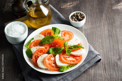 Close-up photo of caprese salad with ripe tomatoes, basil, buffalo mozzarella cheese. Italian and Mediterranean food concept. Fresh and healthy organic meal. Starter and antipasti. 