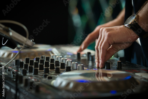 DJ's hands mixing music at disco. Copy space