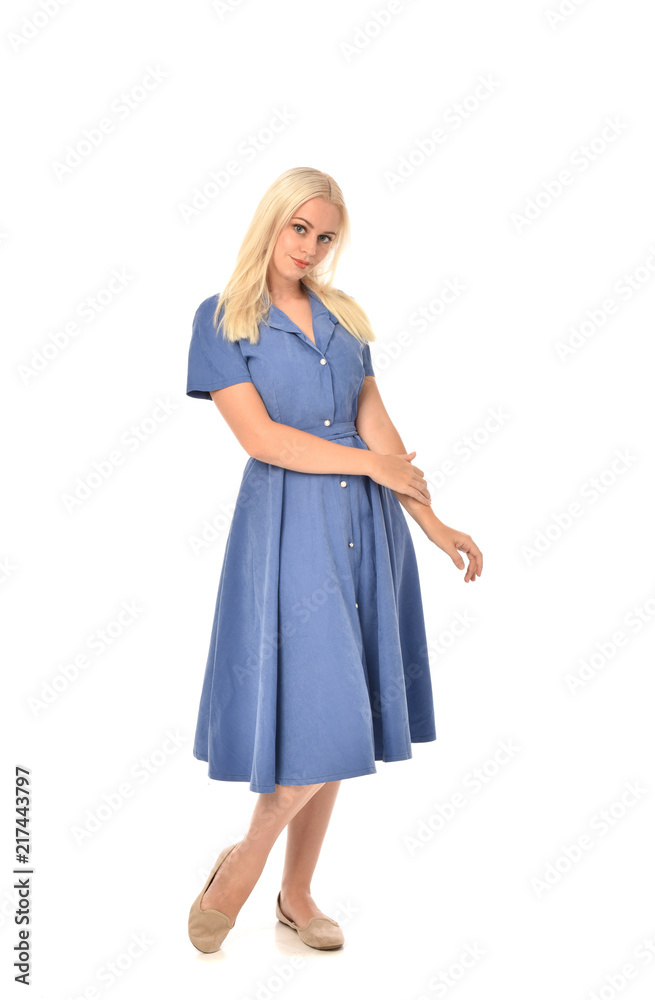 full length portrait of blonde girl wearing blue dress. standing pose. isolated on white studio background. full length portrait of blonde girl wearing blue dress. standing pose. isolated on white studio background.