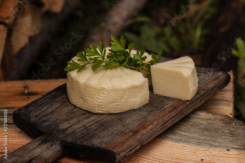Wheel of brazilian traditional cheese Minas on wooden board. Selective focus