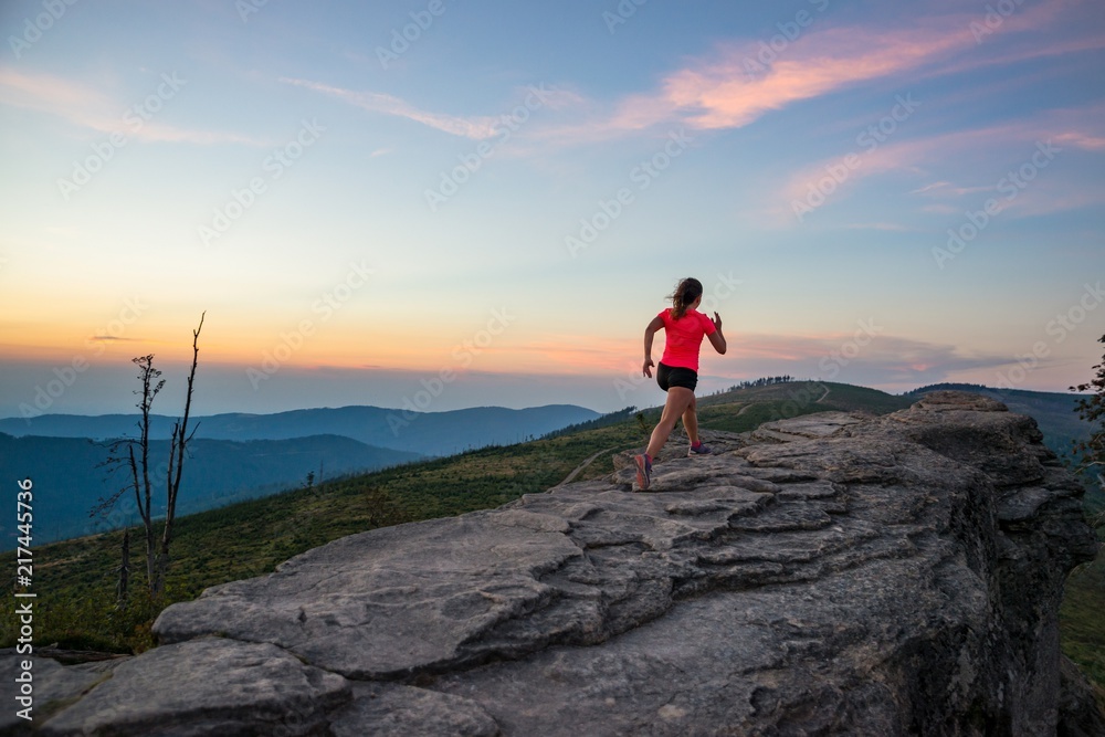 Young woman running on rocks.