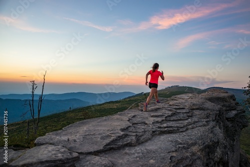 Young woman running on rocks.