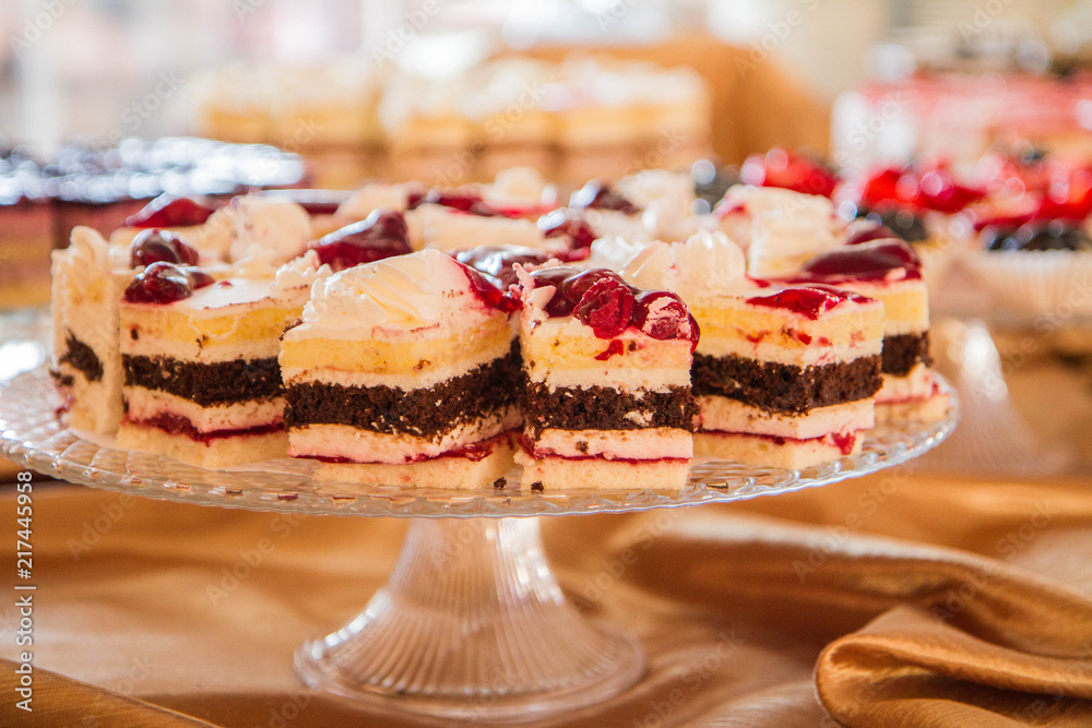 Selection of cakes and pastry set up on cake stands for a party Selection of cakes and pastry set up on cake stands for a party