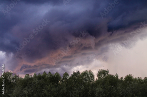 the sky during a thunderstorm over the forest © Anna