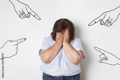 femme ronde pleurant contre un mur photo