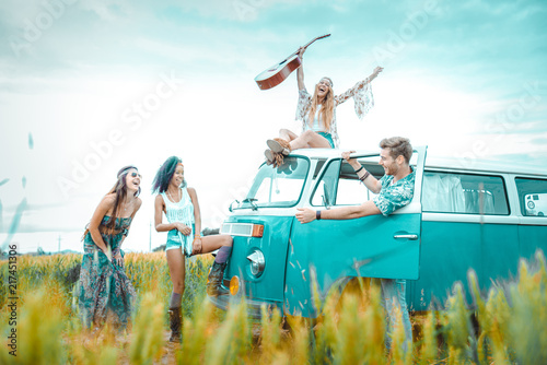 Happy friends driving a vintage minivan photo