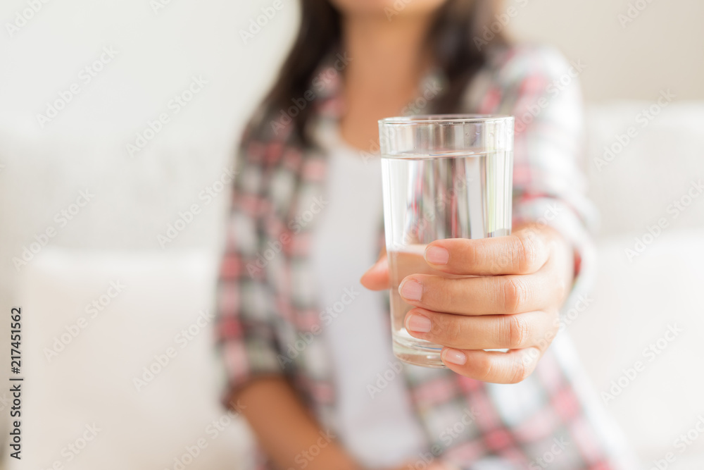 Happy beautiful young woman holding drinking water glass in her hand. Health care concept. Happy beautiful young woman holding drinking water glass in her hand. Health care concept.