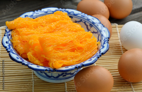 Golden egg strip is Thai desserts made from eggs with Thai style bowl on wooden background ( Thai name is Foi Thong).