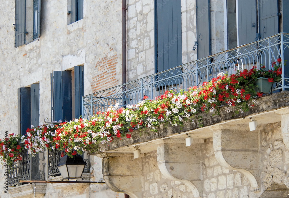 Ville d'Eymet, ville médiévale, balcon en fer forgé fleuri, façade en pierre, département de la Dordogne, France
