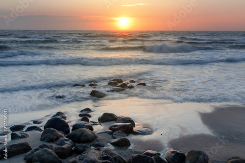 Sunset evening beach overview with waves and wet stones. Danish coastline  Hirtshals in North Jutland in Denmark  Skagerrak  North Sea