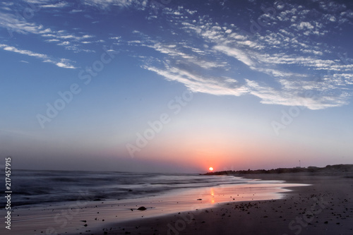 Amazing relaxing and colorful evening sunset with dramatic white clouds at a danish beach. Danish ocean sea, Lønstrup in North Jutland in Denmark, Skagerrak, North Sea