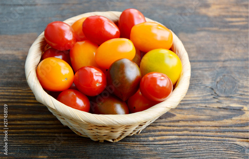 Valokuva Tomato Varieties ,Type and color mixed together in basket on wooden floor