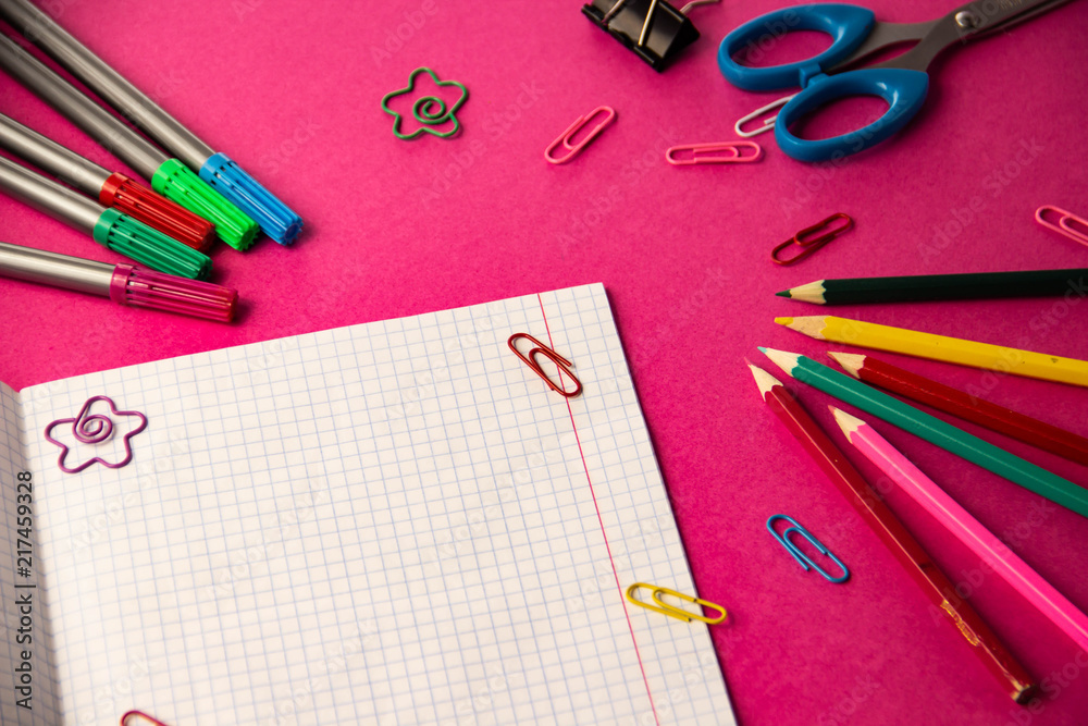 Felt pens, pencils, clips of different colors on a pink background Felt pens, pencils, clips of different colors on a pink background