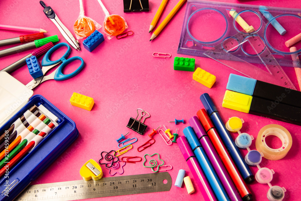 Felt pens, pencils, clips of different colors on a pink background Felt pens, pencils, clips of different colors on a pink background