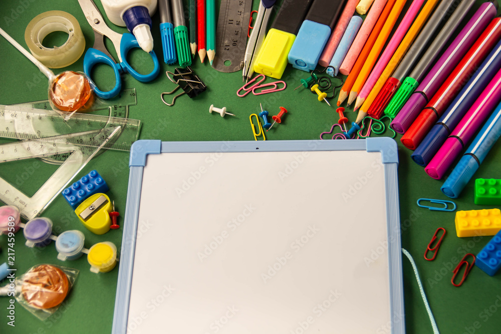 Office supplies for school and a drawing board on a green backgr Office supplies for school and a drawing board on a green backgr